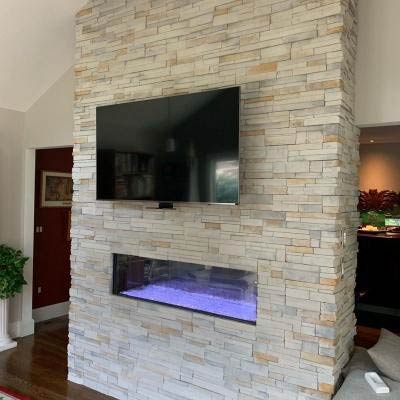 beautiful gas fireplace with wall mounted tv and masonry stone completed by Alpine Fireplaces