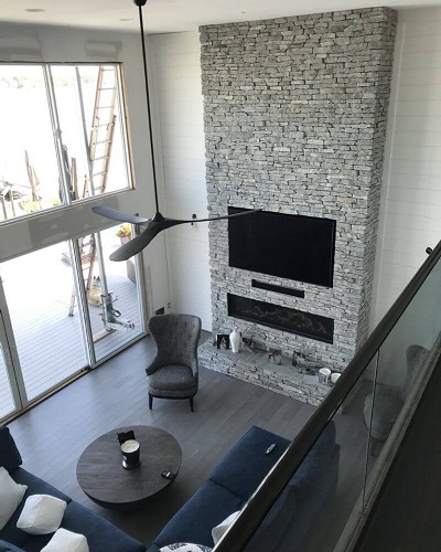 Tall ceilings and masonry stone work fireplace installation accent the room well. Contact Alpine Fireplaces for fireplace installation, maintenance, and repairs.
