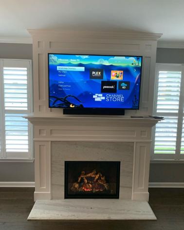 Alpine Fireplaces tv mounted over live active fireplace in home.